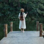 An image depicting a female solo traveler with a backpack exploring a picturesque destination, capturing the essence of an independent adventure.