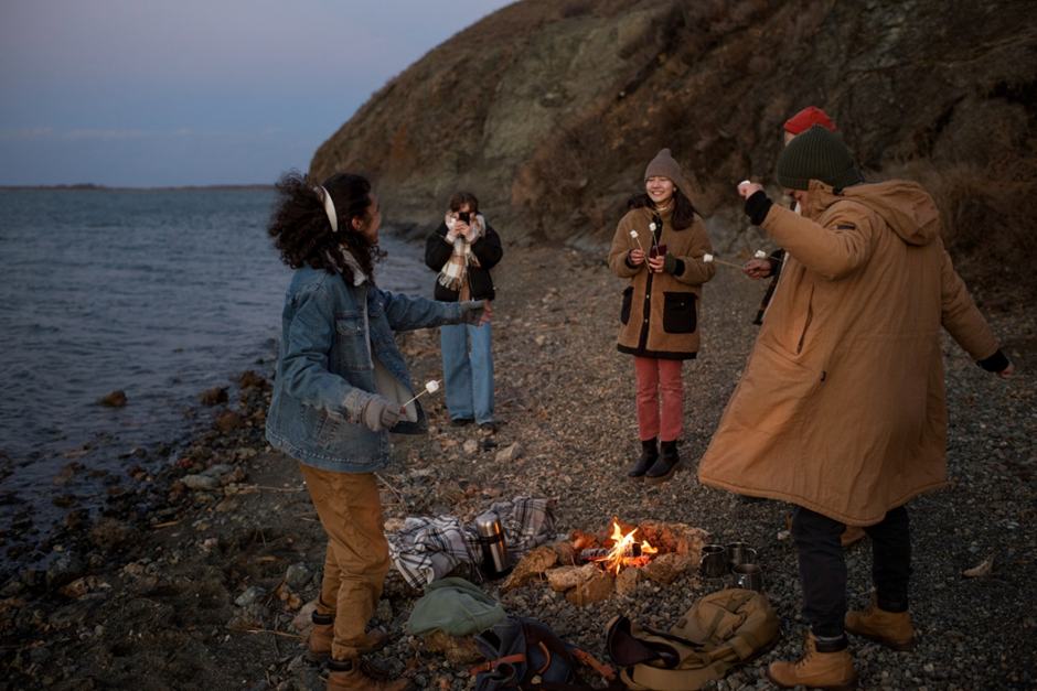 An image depicting different solo travelers bonding over a campfire.