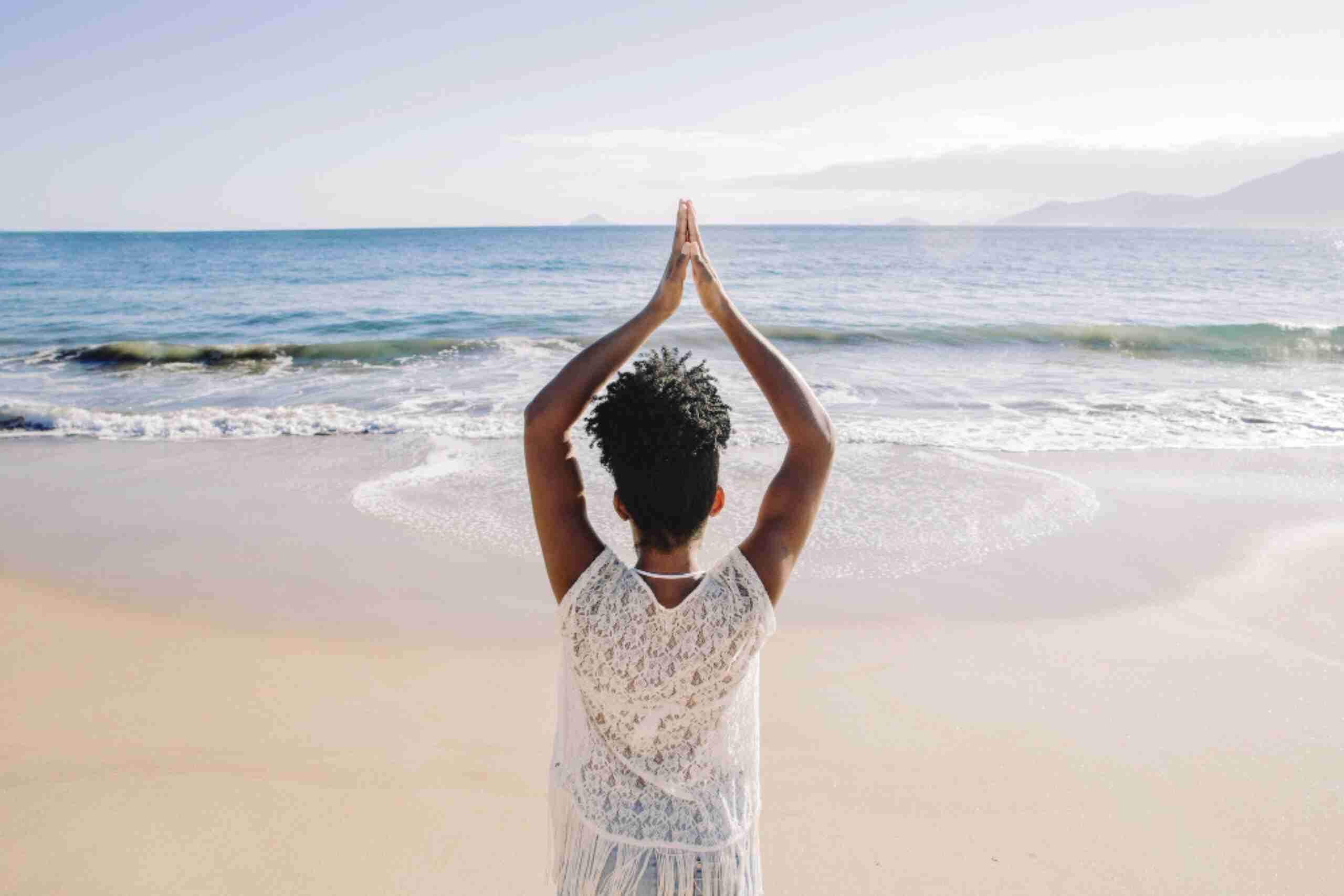 An image showing a traveler meditating at the beach, depicting moments of unwinding.