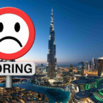 An image showing a city skyline with a ”Boring” signpost.
