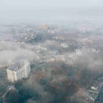 An image showing an aerial view of a city blanketed in a thick haze.