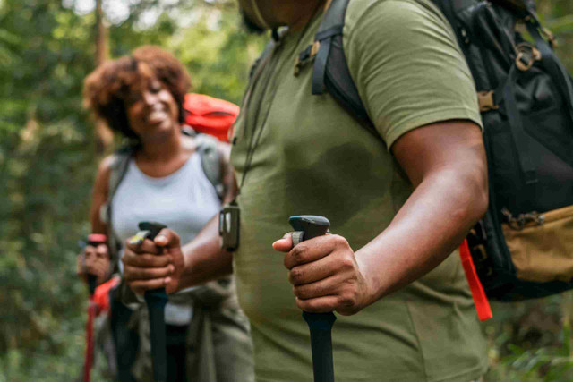 An image showing a couple trekking in the forest.
