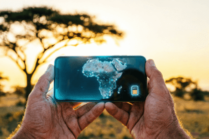 Traveler holding smartphone with digital Africa map and eSIM icon with African savanna background