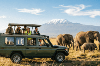 Open-roof safari vehicle on the golden savannah of Maasai Mara with elephants and Mount Kilimanjaro in the background, perfect for a Kenya safari guide for first-time visitors.